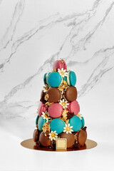 Colorful macarons forming a pyramid on marble background