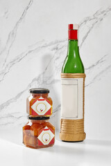 Luxardo maraschino liqueur bottle and baba al maraschino jars displayed on marble surface