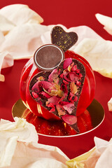 Red heart-shaped cake celebrating valentine's day with rose petals and chocolate