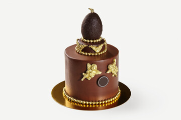 Delicious chocolate cake decorated with golden chocolate angels and egg topper