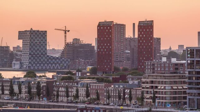 Panoramic aerial timelapse of Katendrecht peninsula and Maashaven harbour at sunset in Rotterdam, The Netherlands. Features city skyline, modern skyscrapers and traditional Dutch waterfront houses