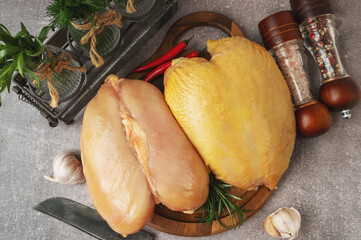 Farmstead homemade chicken breasts with and without skin. Raw chicken breast fillet with rosemary and spices on a wooden cutting board. Top view