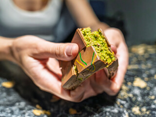 A detailed close up of a woman's hands breaking open the viral Dubai chocolate with its famous...