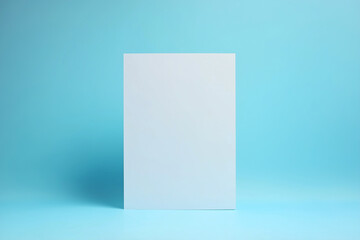 Naklejka premium Blank A4 paper standing upright against a soft blue background