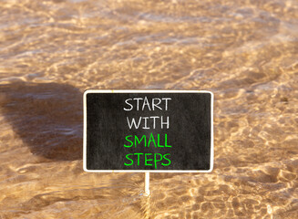 Naklejka premium Start with small steps symbol. Concept words phrase Start with small steps on beautiful black blackboard. Beautiful Red sea water background. Business Start with small steps concept. Copy space.