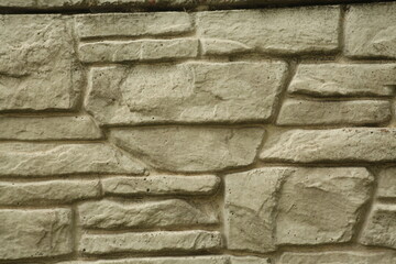 Background. A wall of grey stones. Light falls from above.