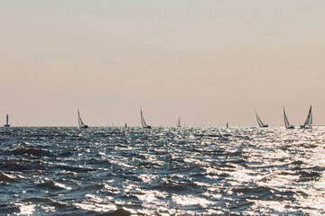 Sailing regatta in the Gulf of Finland at sunset, few sailing yachts competing in a race, splashing...