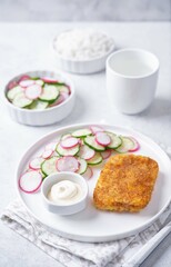 Fried pollock fish with cream sauce and cucumber and radish salad