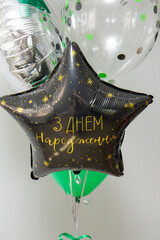 black star foil balloon with the inscription happy birthday