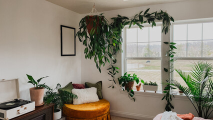 Cozy Boho Room with Hanging Plants, Record Player, Velvet Ottoman, and Scenic Window View, Sunlit Indoor Jungle with Pillows and Houseplants in Warm Modern Interior