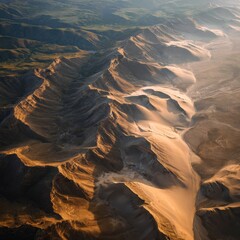 Panoramic aerial view of a majestic mountain range, bathed in sunlight, revealing intricate textures and shadows
