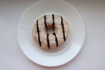  A glazed milk and chocolate doughnut with fillings on a white background, 
