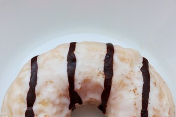  A glazed milk and chocolate doughnut with fillings on a white background, 
