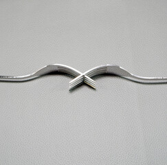 Silver forks combine together placed on grey leather mattress background close-up view flat lay...