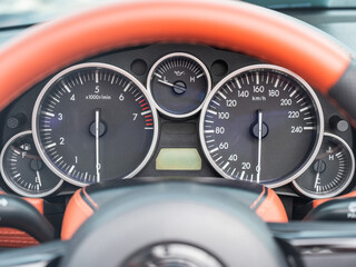 Close-Up View of a Sports Car Dashboard Displaying Gauges. 