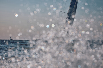 Sailing regatta in the Gulf of Finland at sunset, sailing yacht competing in a race, splashing...
