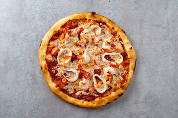 A warm, freshly baked seafood pizza showcases a crispy crust topped with succulent shrimp, tender squid, and juicy tomatoes, inviting delicious flavors in every bite