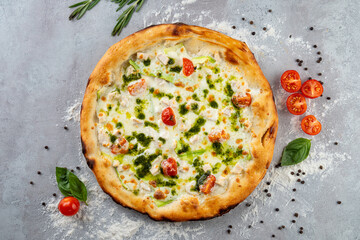 Delight in a circular artisan pizza adorned with vibrant cherry tomatoes, creamy sauce, and aromatic herbs, inviting a savory dining experience on a rustic backdrop