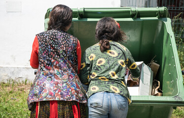 poor people searching in a dumpster