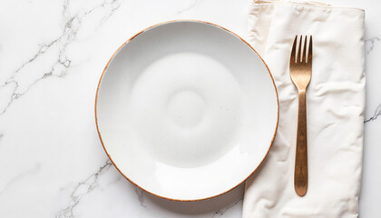 White ceramic plate with gold rim and fork on marble background  