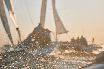 Sailing regatta in the Gulf of Finland at sunset, two sailing yachts competing in a race, splashing...