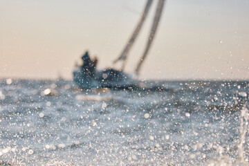 Sailing regatta in the Gulf of Finland at sunset, sailing yacht competing in a race, splashing...