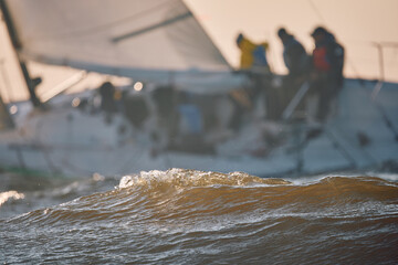 Sailing regatta in the Gulf of Finland at sunset, sailing yacht competing in a race, splashing...