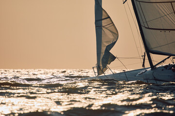 Sailing regatta in the Gulf of Finland at sunset, sailing yacht competing in a race, splashing...