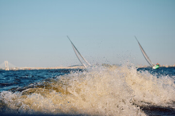 Sailing regatta in the Gulf of Finland at sunset, two sailing yachts competing in a race, splashing...