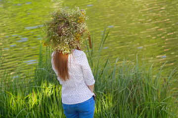 Girl in a wreath of grasses by the river. The national Slavic holiday of Ivan Kupala