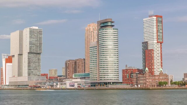 Rotterdam skyline timelapse from Nieuwe Maas River bank to Wilhelminapier and Kop van Zuid. Modern skyscrapers, ship terminal and waterfront in this redeveloped former harbor area with boats passing