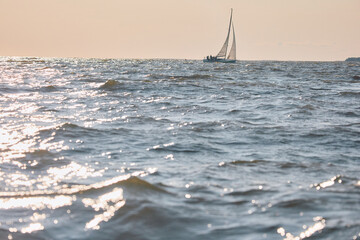 Sailing regatta in the Gulf of Finland at sunset, sailing yacht competing in a race, splashing...