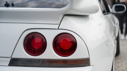 Sleek White Sports Car Rear with Red Lights. 