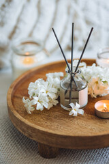 Burning candles, aroma fragrance natural organic diffuser, wooden bamboo tray. Concept of cozy home space for meditation, relaxation. Spiritual aura cleansing routine. Spring hyacinth blossom scent