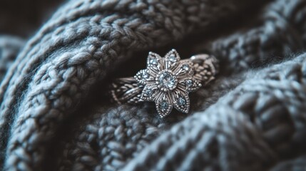 Fototapeta premium Close-up of a delicate flower-shaped ring on a knitted fabric.