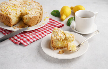 A piece of Freshly Baked Lemon Pie sbriciolare, Delicious Citrus Tart on red napkin over white kitchen Background, copy space