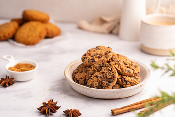 Golden chocolate chip cookies next to a glass of milk on white kitchen background. High quality photo