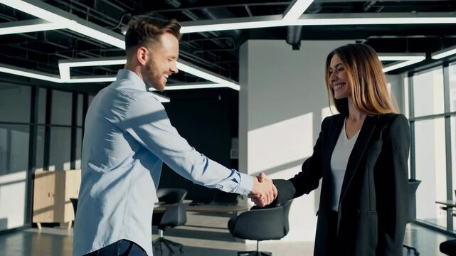 man and woman shaking hands in an office, collaborative teamwork