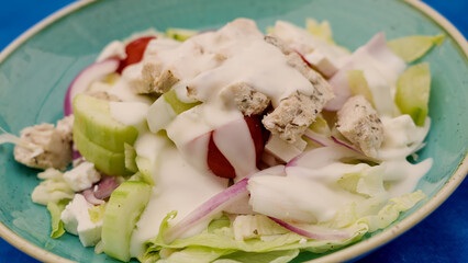 Close up of a vibrant Mediterranean salad featuring grilled chicken, feta cheese, fresh vegetables,...