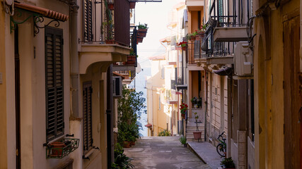 Obraz premium Picturesque alley with traditional houses and balconies overlooking the Mediterranean Sea in Scilla, a charming village in Southern Italy