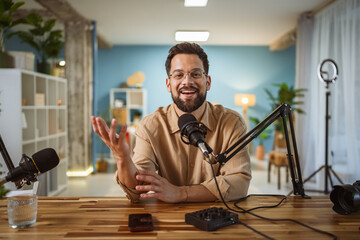 Adult man with eyeglasses and headphones smile while record a podcast