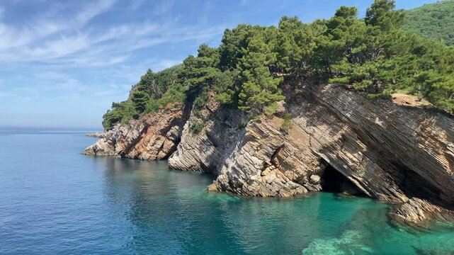 Crystal clear sea water with rocks and mountains turquoise blue vivid colors Montenegro seacoast Petrovac Video 4K
