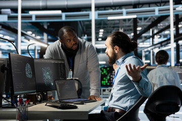 Data center manager berating employee during intense discussion, reproaching performance issues. Technician in server hub receiving verbal reprimand from upset management team leader