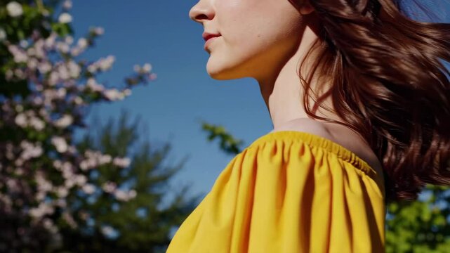 portrait of a brunette 20 year old girl with green eyes in a yellow dress on a spring hill 