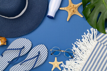 Blue beach accessories on color background, top view. Copy space for text