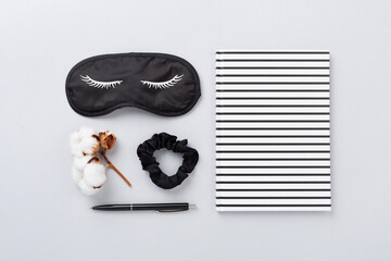 Sleeping mask with accessories on color background, top view. Sleeping routine concept