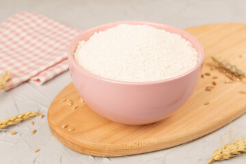 Bowl with spelt flour on concrete background