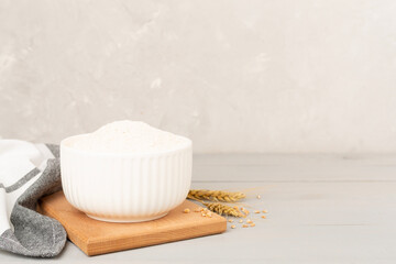Bowl with spelt flour on concrete background