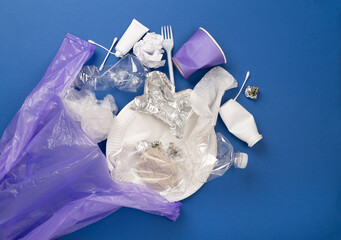 Bag with unsorted waste on color background, top view