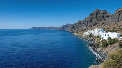 Scenic coastal view of white buildings nestled on a volcanic hillside.
